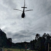 Helicopter setting up drill rig